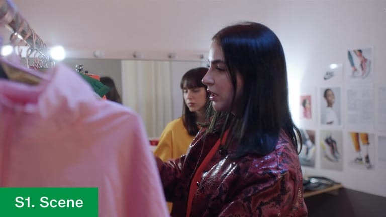 Film still labelled 1. Scene — the stylist working through a rail of clothing