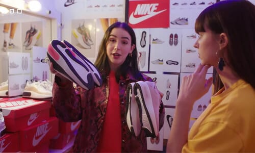 The stylist presenting a shoe to camera in the sneaker room