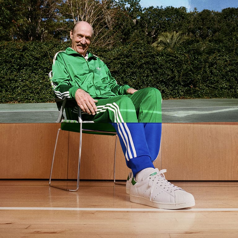 Stan Smith seated courtside, the frame split between tennis court and basketball court